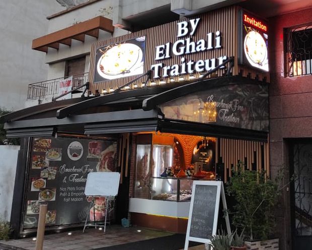 Illuminated caterer restaurant sign at night