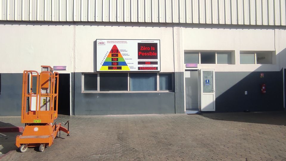 LED HSE 'days without accident' board installed on an industrial site facade
