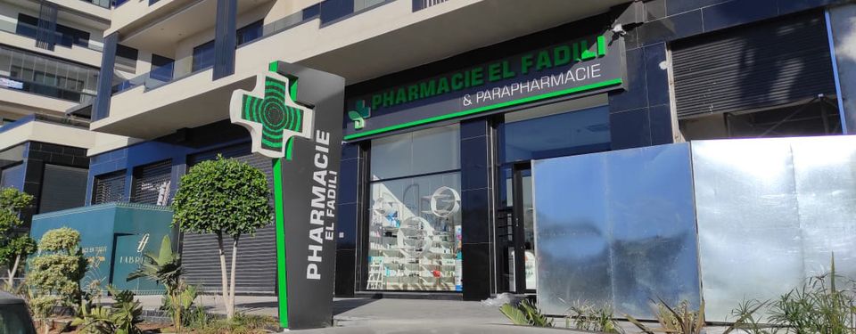 Pharmacy totem with illuminated cross in front of the store
